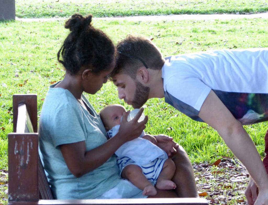 a young family in the park with an infant