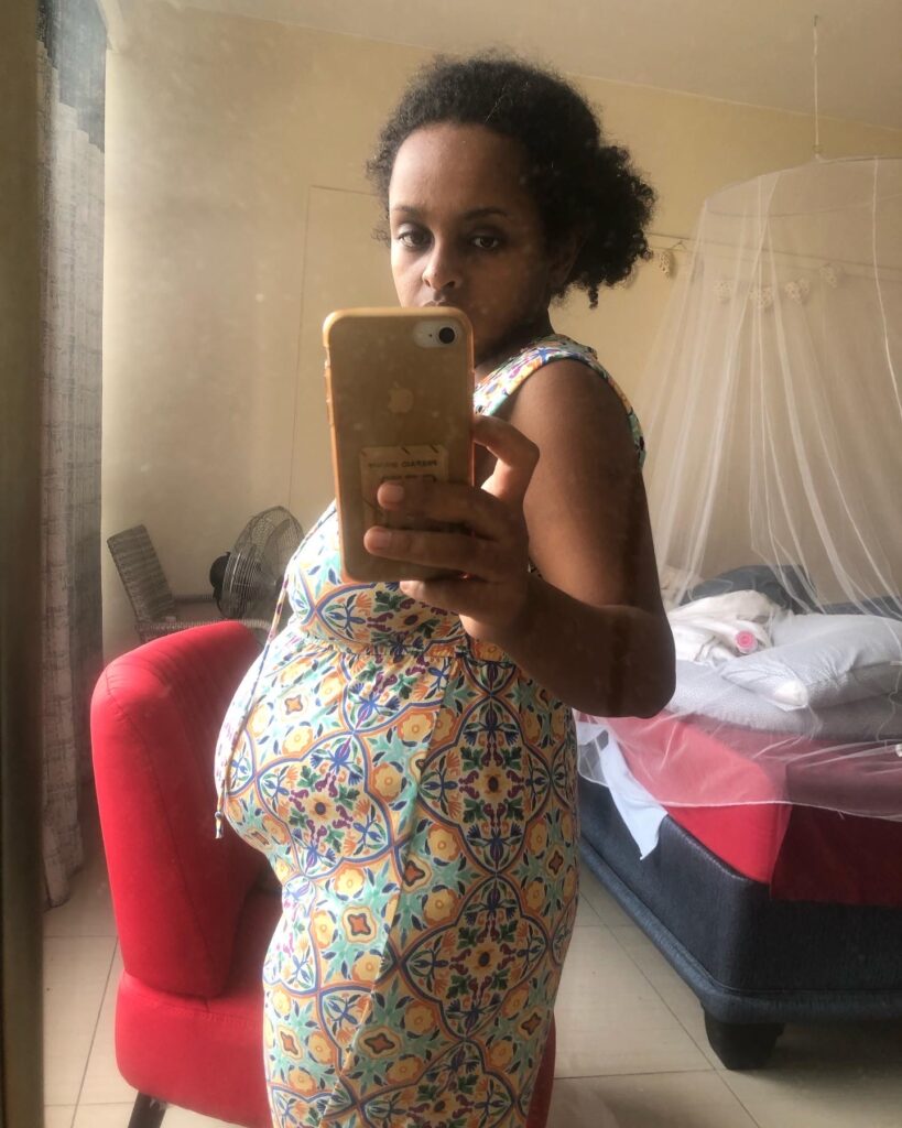 a woman taking a picture of herself infront of a mirror with her postpartum body