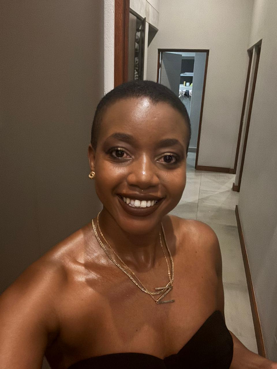 A beautiful black woman with short hair in a strapless black dress
