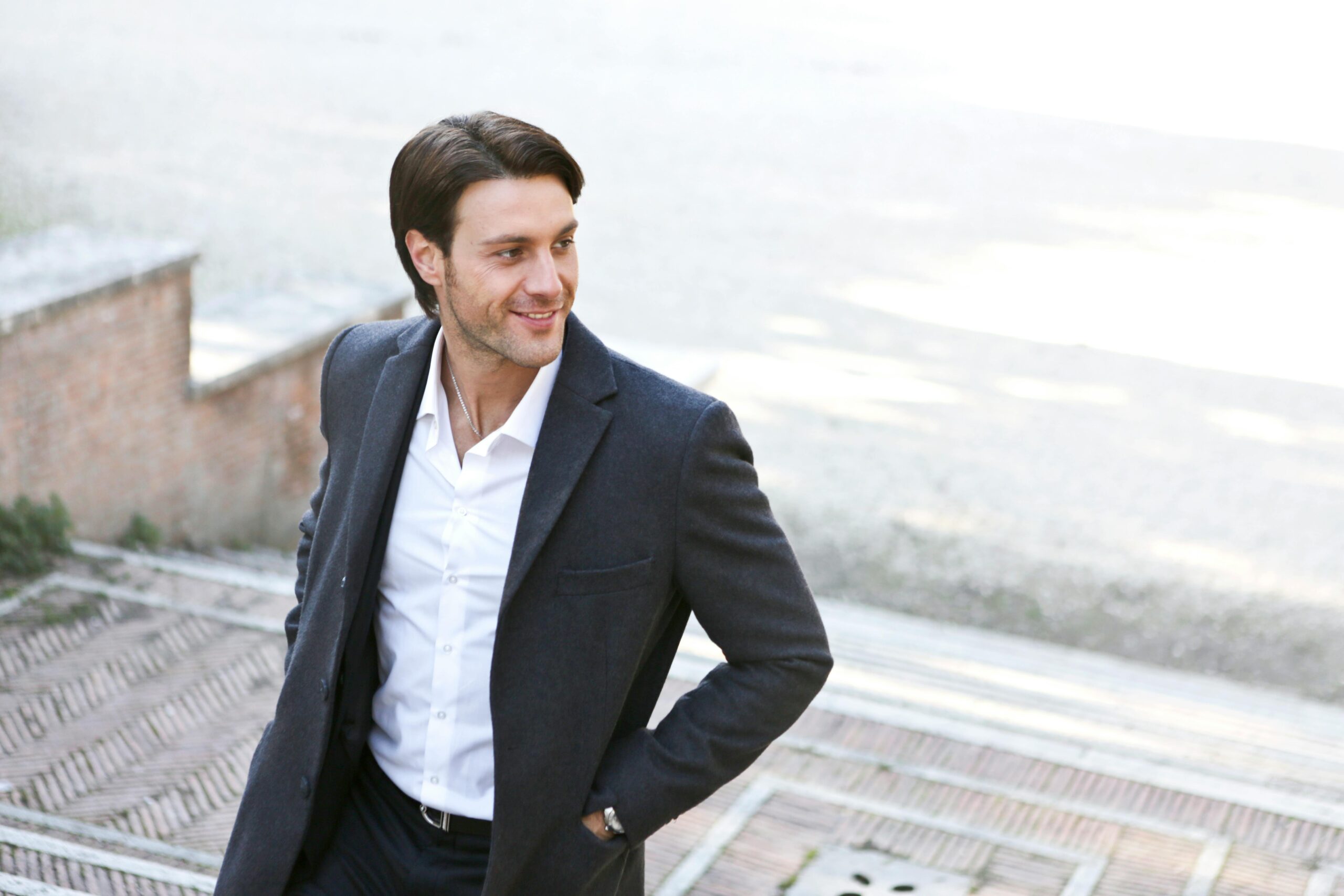 white man in his 30s wearing a white shirt and formal black jacket