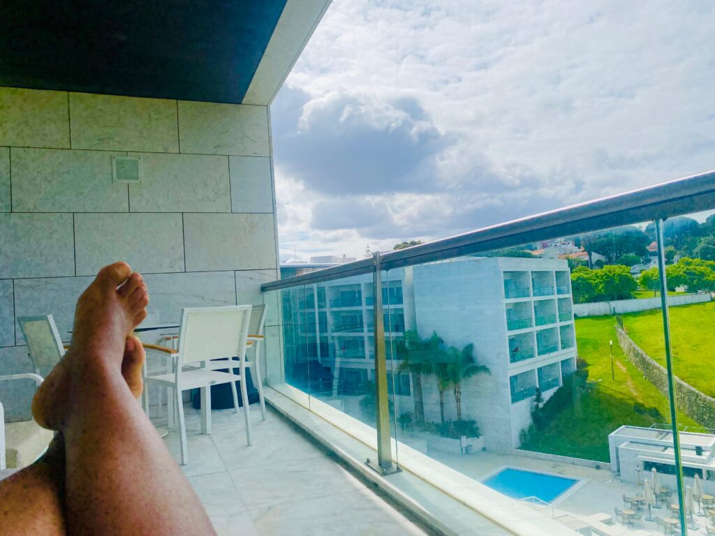 best advice from my therapist, a picture of lounging feet on a hotel balcony with a pool in the distance