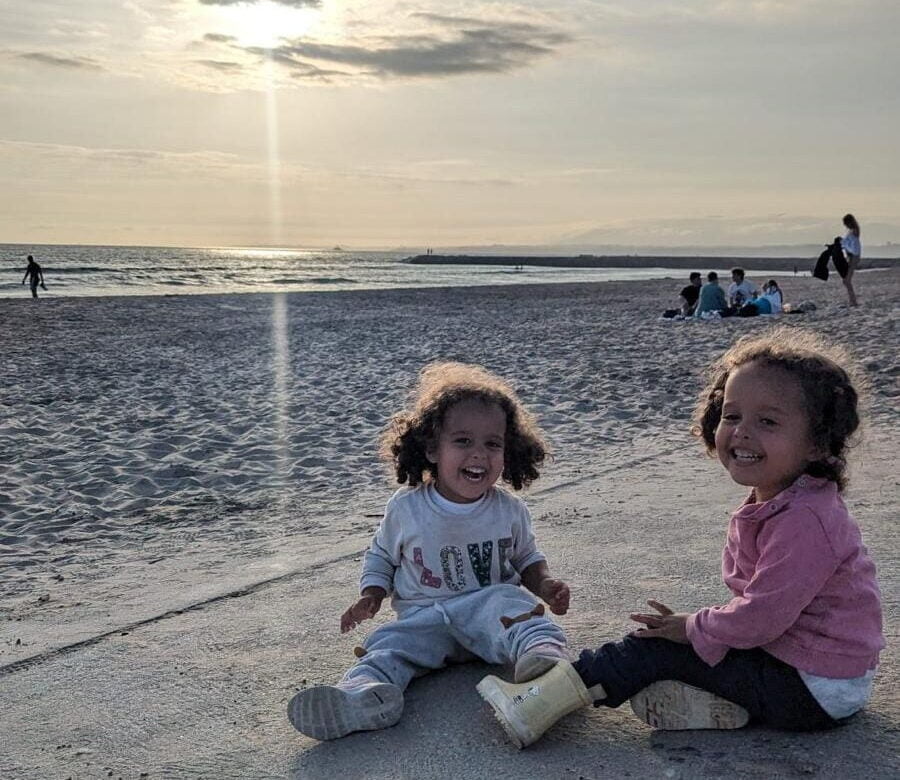 sunset beach girls twin girls at a beach in portugal at sunset - why we moved to portugal