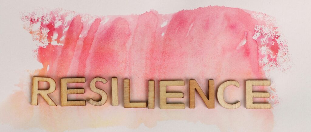 A picture of "RESILIENCE" written in wooden letters with a pink background - related to a post on "do you need to be smart to be successful?"