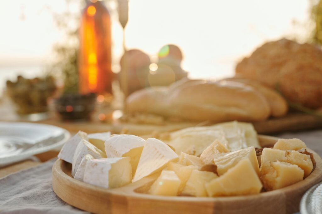 Cheese board, baguette, and wine picnic for blog post on European cuisine