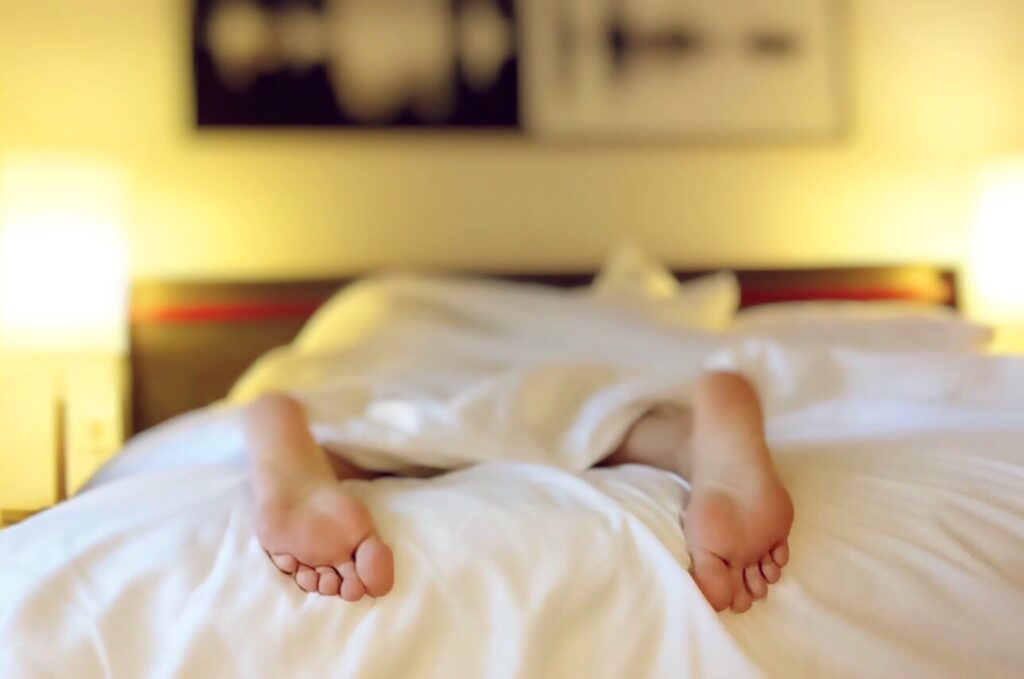 woman's feet seen in bed under bedsheets linked to blog post entitled "scheduled downtime: it's good to do nothing once in a while"