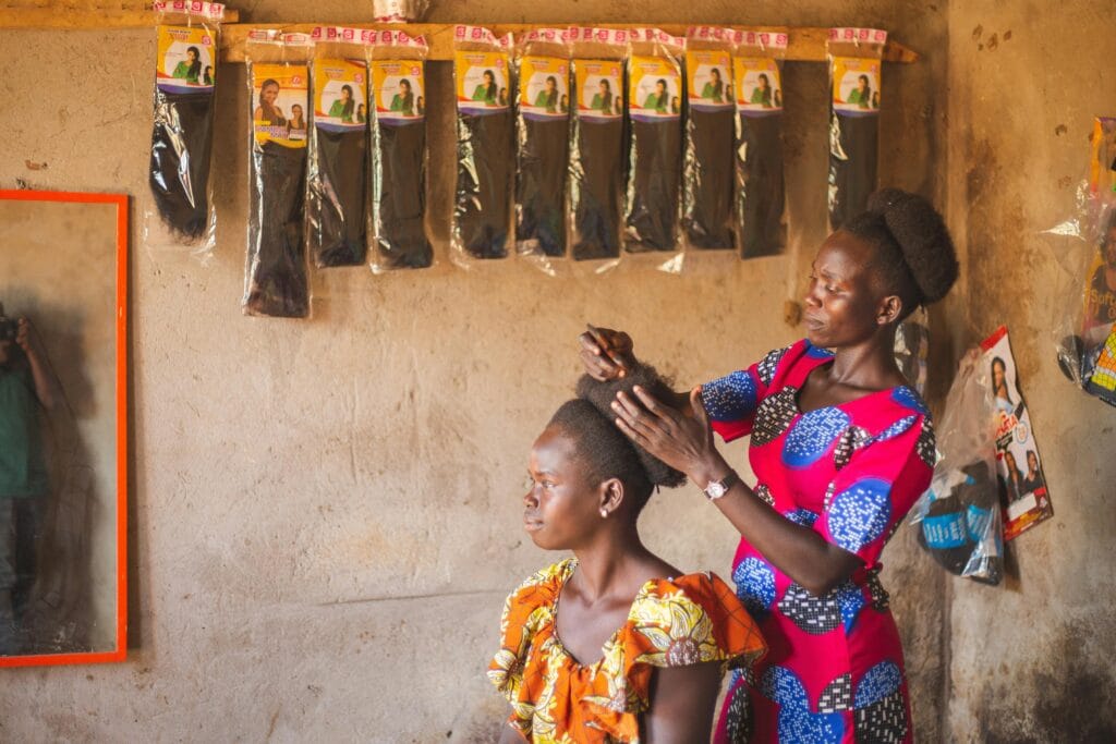 Rural African hair salon with natural hair and hair extensions hanging on the wall.